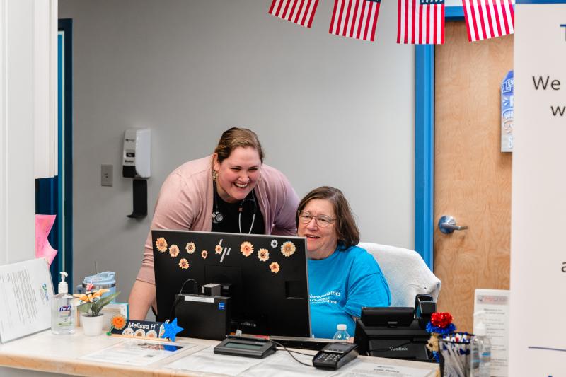 two women smiling at a computer